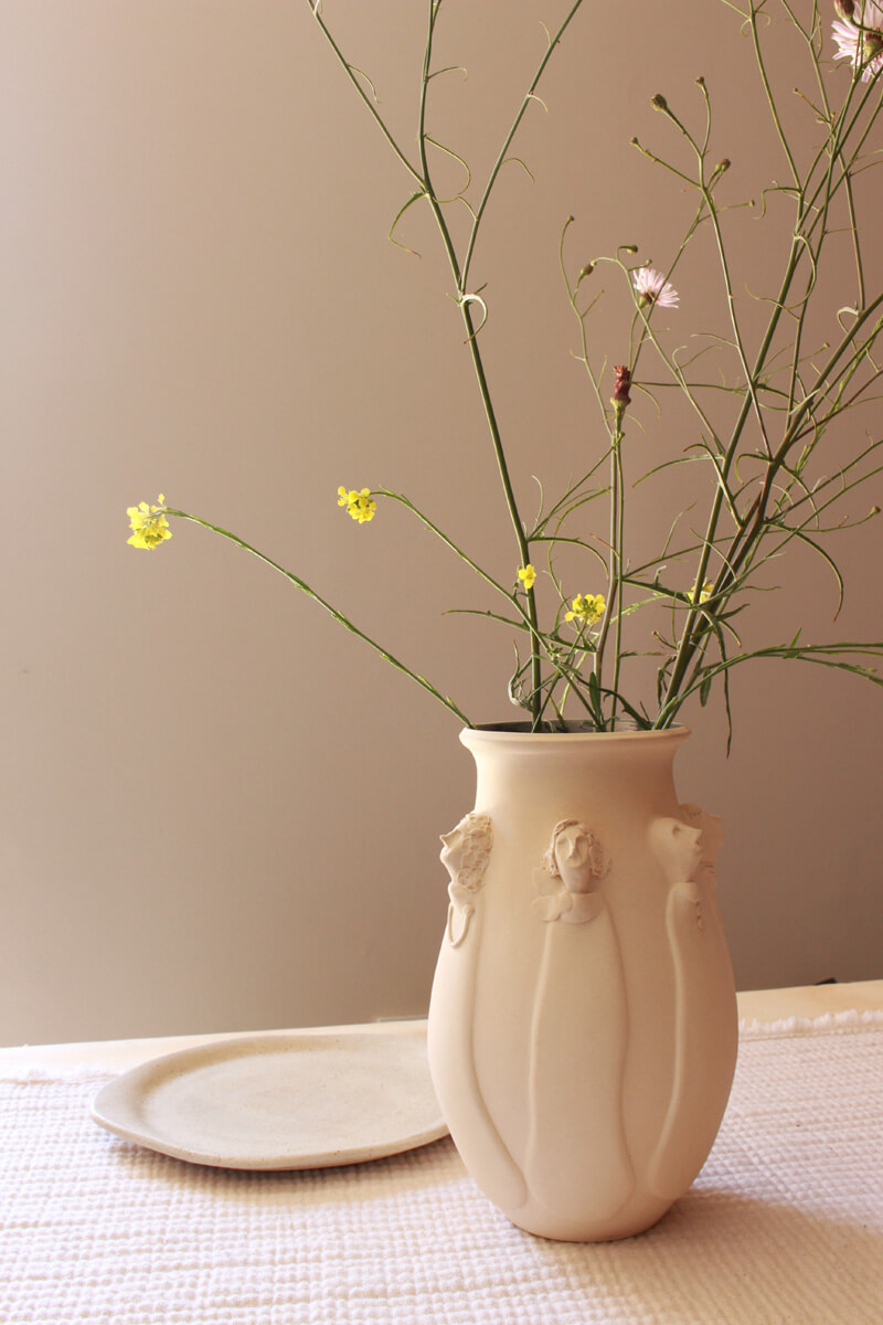 Handmade ceramic vase with delicately sculpted figures in Modern interior