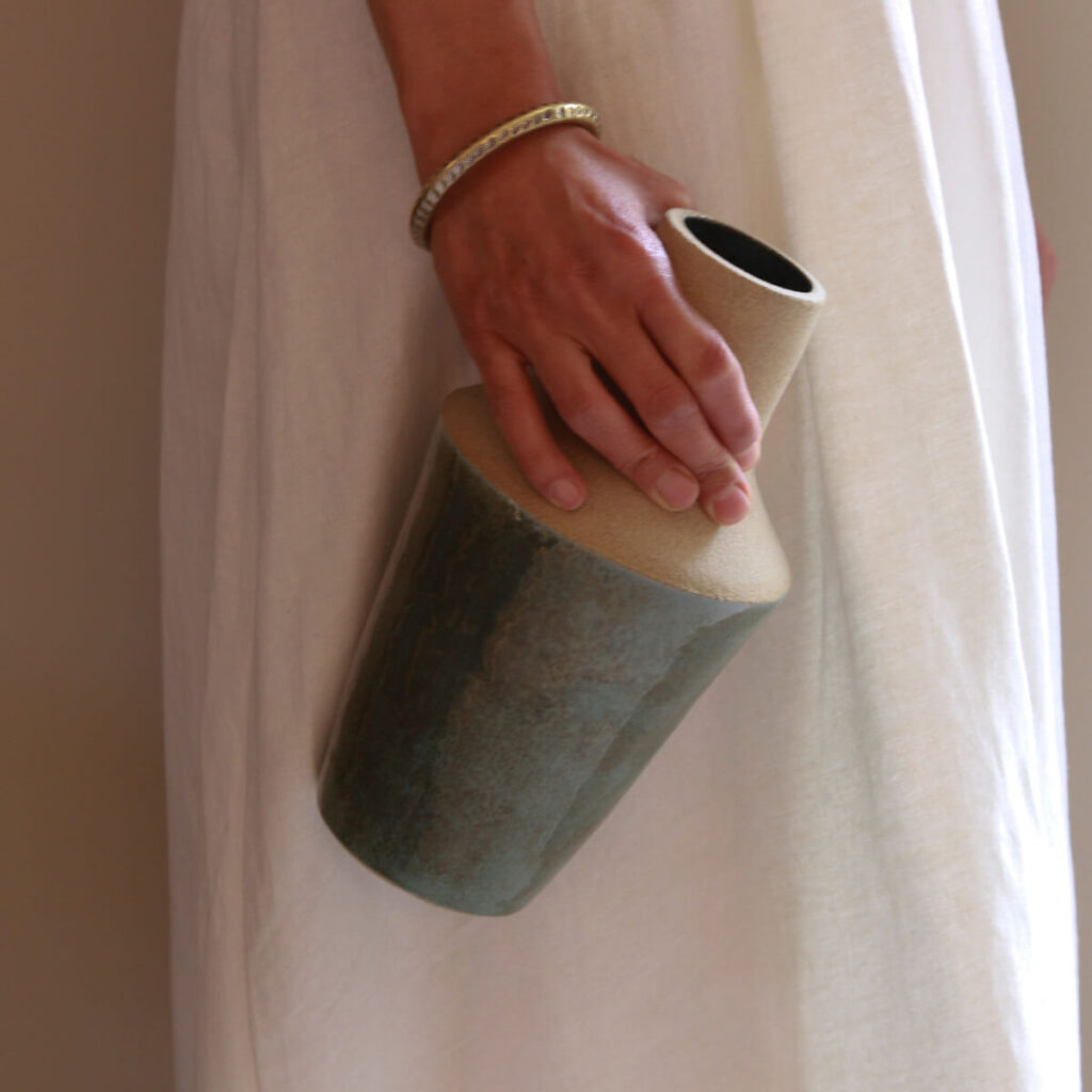 Hand holding Reflection handmade ceramic vase with sculptural industrial form