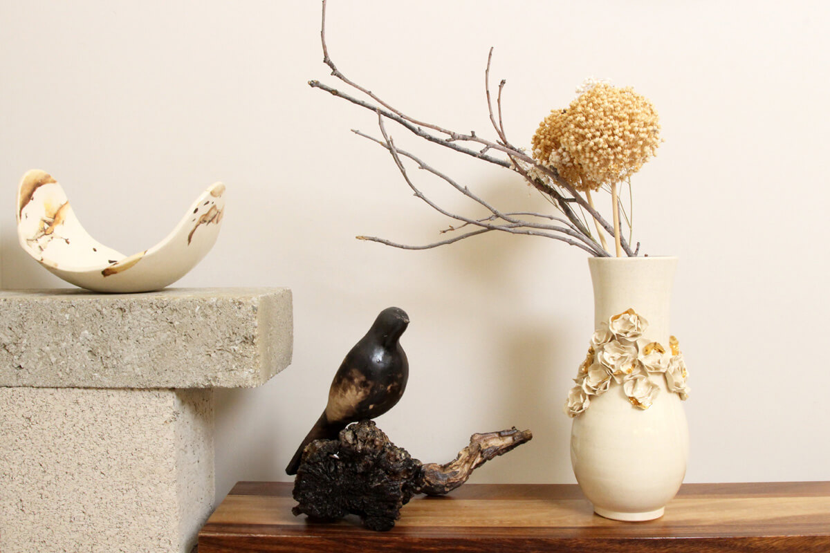 Floral ceramic vase styled on shelf with branches and decor in modern interior