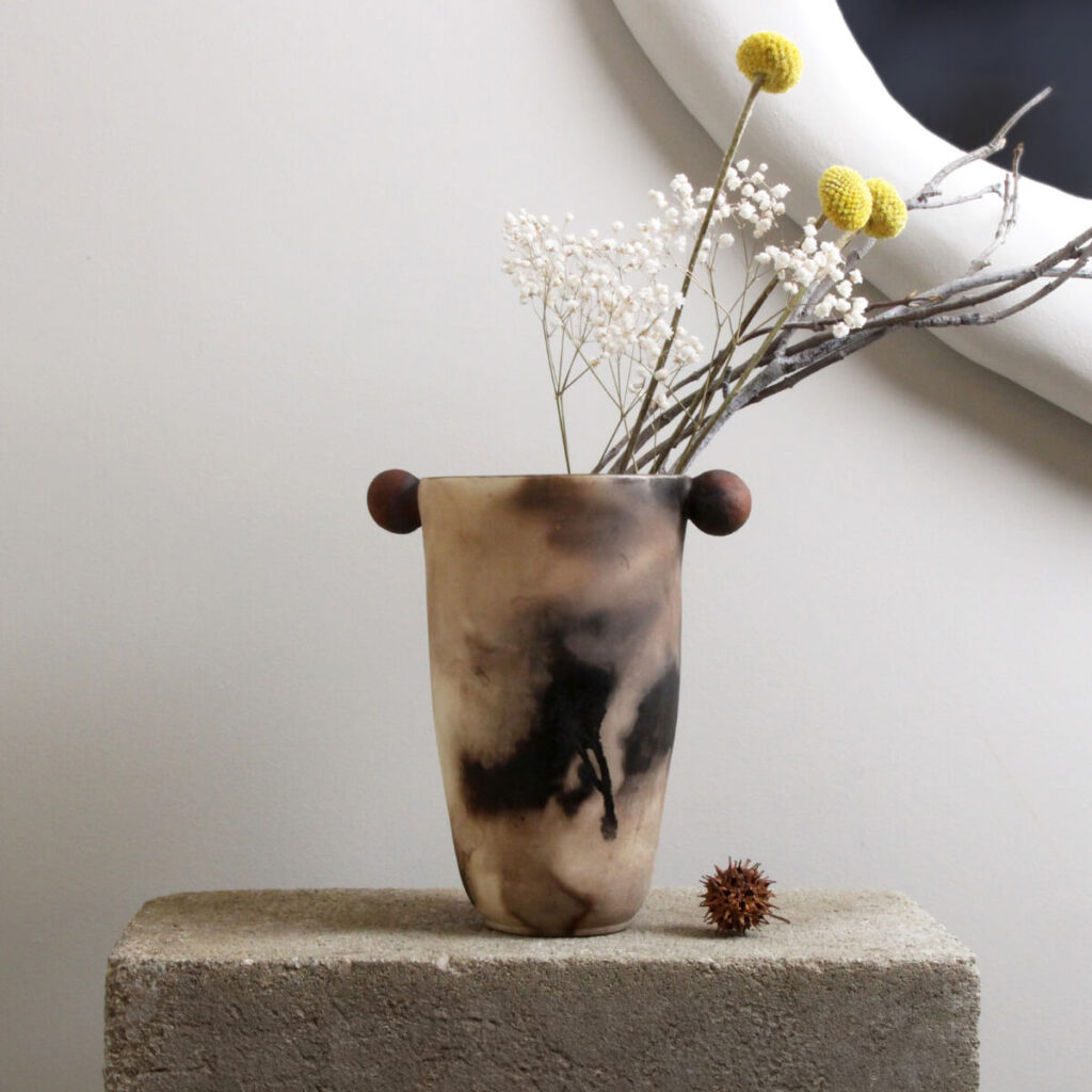 Fired Phantasm ceramic vase with red sculpted side handles, front view