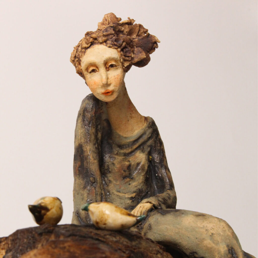 Keeper of Flight handmade ceramic sculpture with seated figure and birds on branch-like base