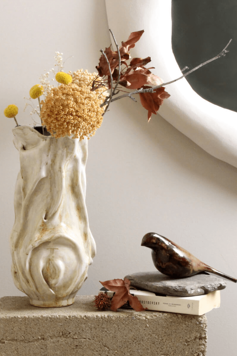 Ceramic vase with dried flowers and bird