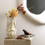 Folded Still handmade ceramic vase styled with dried stems on a concrete block